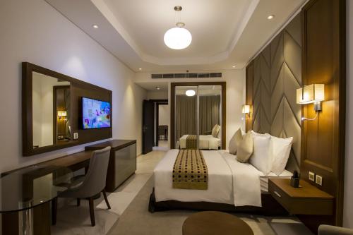 a hotel room with a bed and a desk and a television at TIME Onyx Hotel Apartments in Dubai