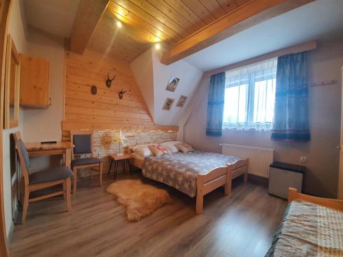 a bedroom with a bed and a desk in a room at Willa 14 in Zakopane