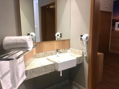 a bathroom with a sink and a mirror at Hotelog in Campina Grande do Sul