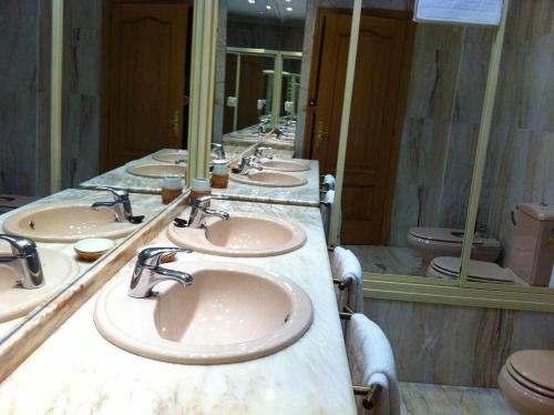 普拉森西亞的住宿－Plasencia Santa Ana，浴室设有一排盥洗盆和卫生间