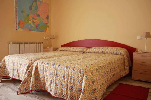 普拉森西亞的住宿－Plasencia Santa Ana，一间卧室配有一张带花卉床罩的床