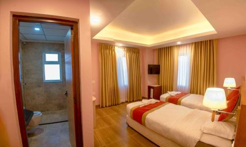 a hotel room with two beds and a bathroom at Hotel Krishna Kathmandu in Kathmandu