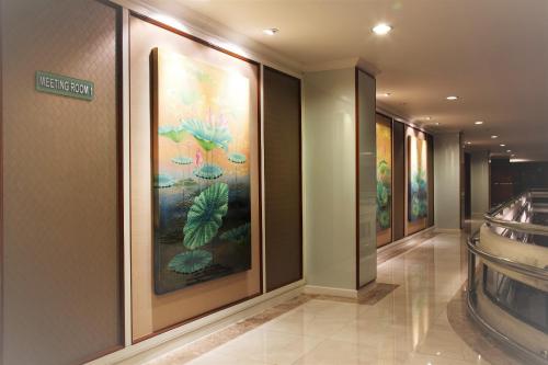 a hallway with paintings of plants on the wall at Nasa Bangkok in Bangkok