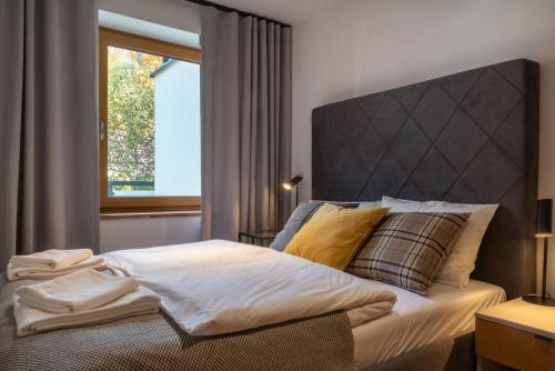 a bedroom with a bed with a large headboard and a window at Willa 74 Wisła in Wisła