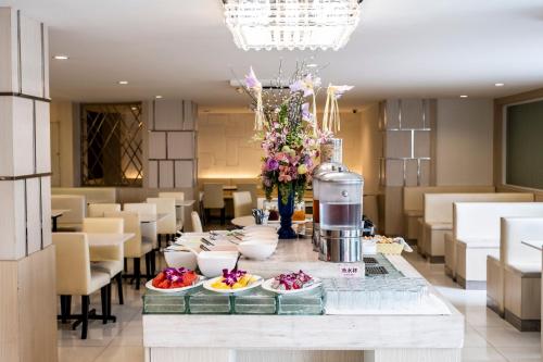 a dining room with a table with plates of food at The Airport Courtyard Suvarnabhumi Airport in Bangkok