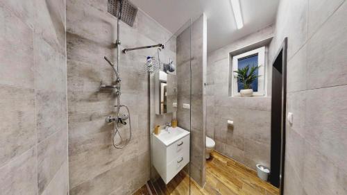 a bathroom with a shower and a toilet and a sink at The Hideout in Žilina