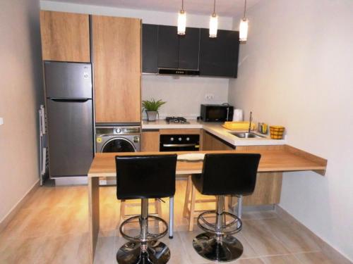 a kitchen with a counter and two bar stools at Magnifique Appartement au coeur de la Senegambia Kololi in Banjul