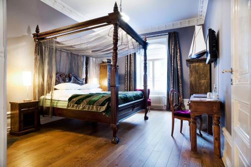 斯德哥爾摩的住宿－赫爾斯坦酒店，一间卧室配有一张天蓬床和一张书桌