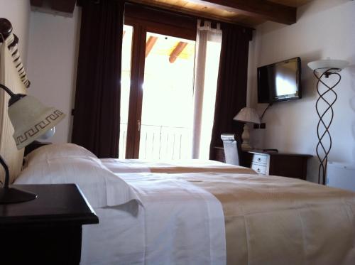 a bedroom with a bed and a tv and a window at Antico Noce in Granarolo dellʼEmilia