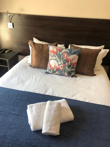 a bed with pillows and pillows on top of it at 314 on Clark Guest House in Pretoria