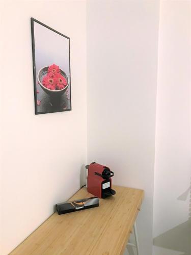 a table with a mirror and a bowl of red flowers at Bel appartement design tout confort (Parking Gratuit) à 10 minutes de Bordeaux in Cenon
