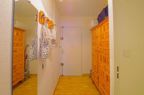 a room with a hallway with a door and wooden cabinets at Studio à 100m de la plage avec balcon - 66 in Canet-en-Roussillon