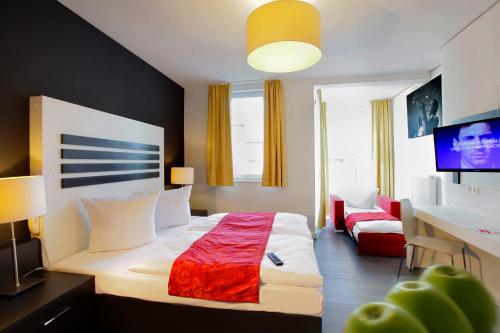 a bedroom with a bed and a desk and a television at INA Boutique 072 Hamburg St Georg in Hamburg