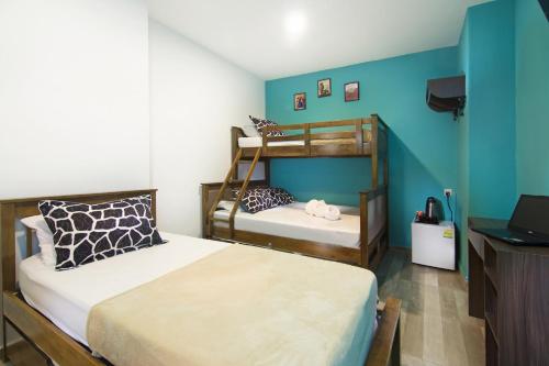 two bunk beds in a room with blue walls at Tai Hoe Hotel in Singapore