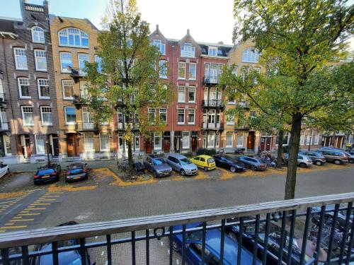 een uitzicht op een straat met geparkeerde auto's en gebouwen bij Hotel Washington in Amsterdam