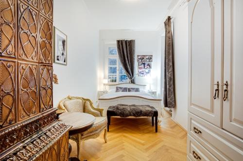 a living room with a table and a chair and a piano at Lovecký zámeček pod Milešovkou in Teplice