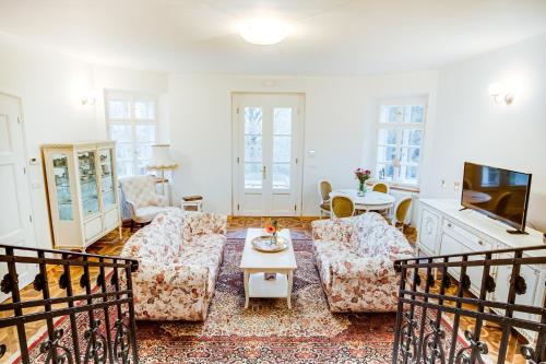 a living room with two couches and a tv at Lovecký zámeček pod Milešovkou in Teplice