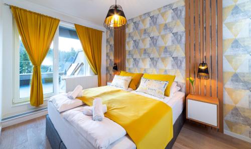 a bedroom with a yellow bed and a window at Olimpijska kuća - A103 in Jahorina