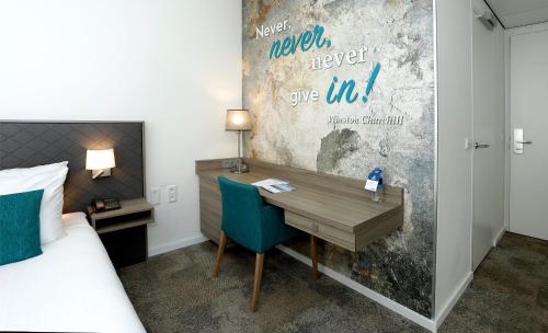 a bedroom with a desk and a bed and a bed and a desk at Churchill hotel Terneuzen in Terneuzen