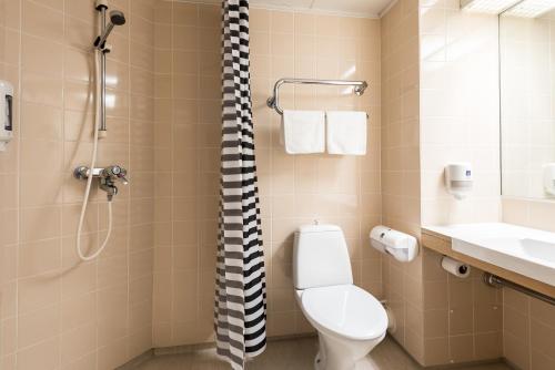 a bathroom with a toilet, sink, and shower stall at Hotel Hermica in Tampere