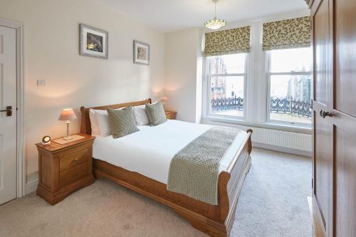 a bedroom with a large bed and two windows at Host & Stay - Church Square Eskape in Whitby