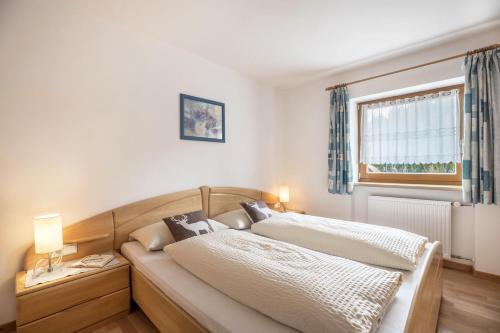 sypialnia z dwoma łóżkami i oknem w obiekcie Haus Belodei - Apt A w mieście San Martino in Badia