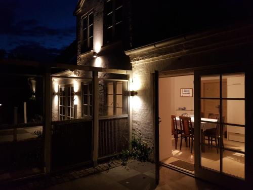 a house with a door open to a patio at night at Fjordvejen Apartments in Gråsten