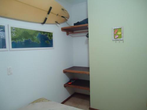 a room with a bed and some shelves in a room at Apartamento em Boracéia no Litoral Norte in Bertioga