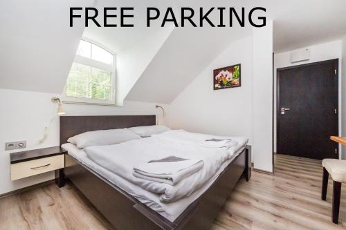 a bed in a room with the words free parking at Nová Hospoda - Hotel & Restaurant in Prague