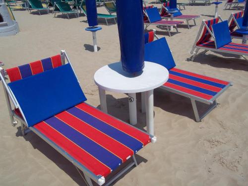 un gruppo di sedie sulla spiaggia di Hotel Italia a Senigallia