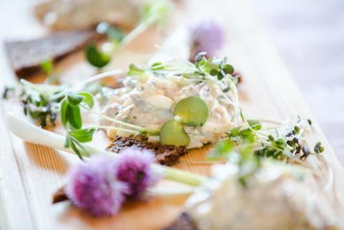 a plate of food on a table with flowers at Hotel Kalkstrand in Pargas