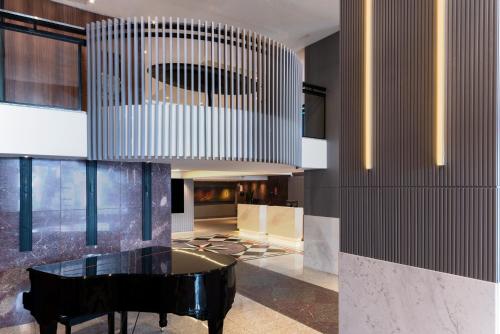 a room with a black piano and a chandelier at Mercure Curitiba Batel in Curitiba