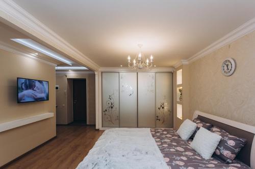 um quarto com uma cama grande e um lustre em Luxury Apartment em Sumy