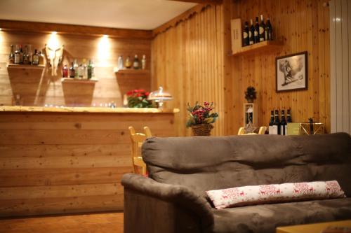 a living room with a couch and a bar at Case Vacanza Perron in Sauze dʼOulx