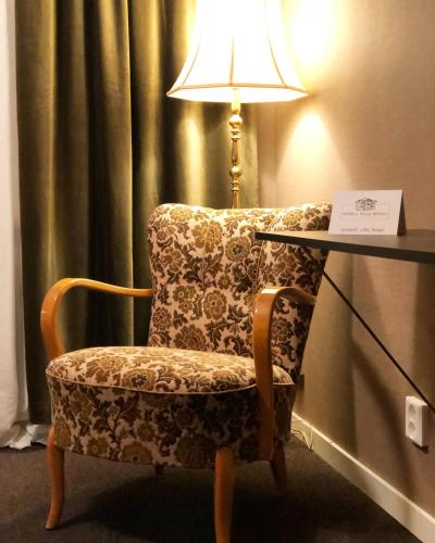 a chair in a room with a table and a lamp at Villa Bergli in Malung