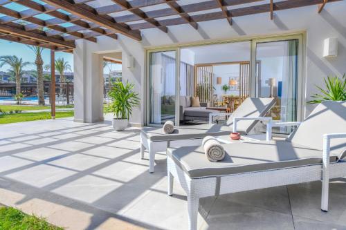a patio with white furniture and glass doors at JAZ Costa Mares in Marsa Alam City