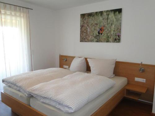 1 cama en un dormitorio con una foto en la pared en Ferienwohnung 2 in den Krautgärten, en Zaberfeld