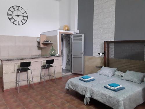 a bedroom with a bed and a kitchen with a clock at INDUSTRIAL LOFT in Guargacho