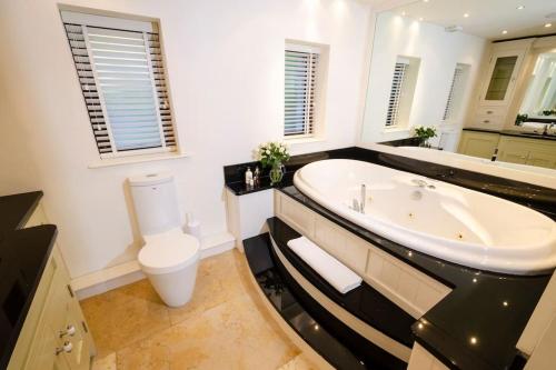 a bathroom with a large tub and a toilet at River House, Clappersgate, Ambleside in Ambleside
