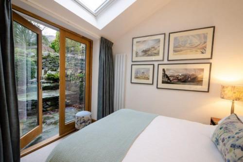 a bedroom with a bed and a large window at Heron Place, Great Langdale in Ambleside