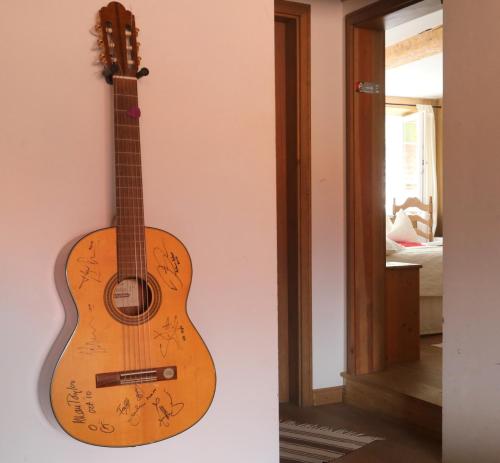 a guitar hanging on a wall next to a door at Fachwerk-Kultur-Pension TangoBrücke in Einbeck
