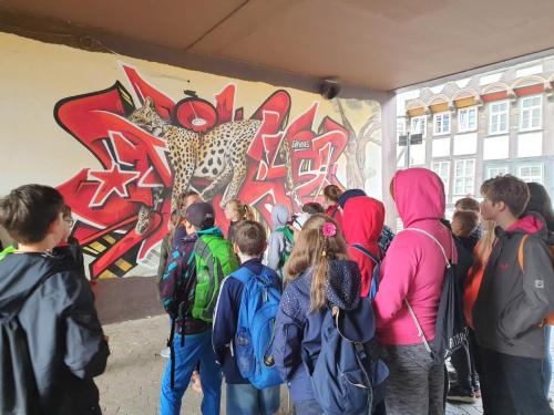 a group of people standing in front of a wall with graffiti at Fachwerk-Kultur-Pension TangoBrücke in Einbeck