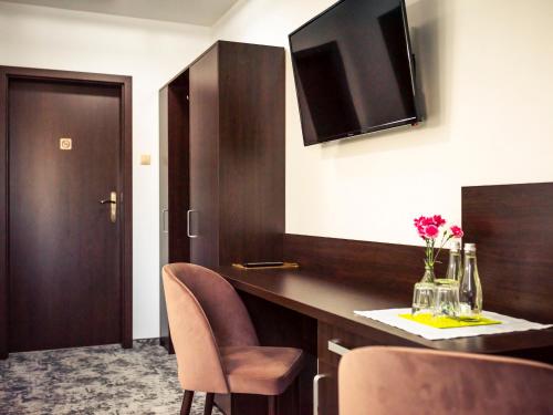 a room with a counter with chairs and a table at Hotel Mużakowski in Łęknica