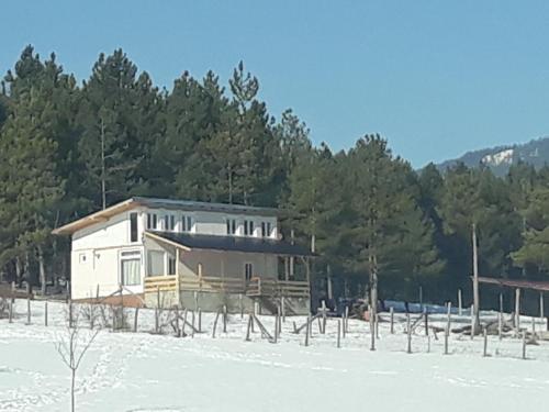 a house in the middle of a snowy field at Ruza vetrova in Divčibare