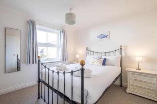um quarto com uma cama e uma janela em April Cottage em Aldeburgh