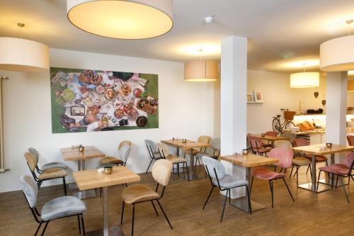 comedor con mesas y sillas de madera en Hotel am Peterstor, en Regensburg