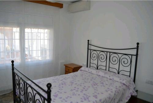 1 dormitorio con cama negra y edredón blanco en R116 Casa adosada con piscina privada en Cunit, en Cunit