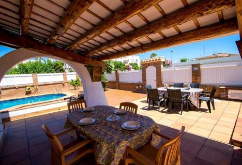 a patio with a table and chairs and a pool at R116 Casa adosada con piscina privada en Cunit in Cunit