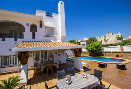 a villa with a swimming pool and a patio at R116 Casa adosada con piscina privada en Cunit in Cunit