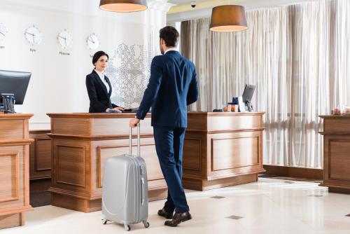 a man with a suitcase in front of a woman at Radisson Blu Hotel, Kyiv Podil City Centre in Kyiv